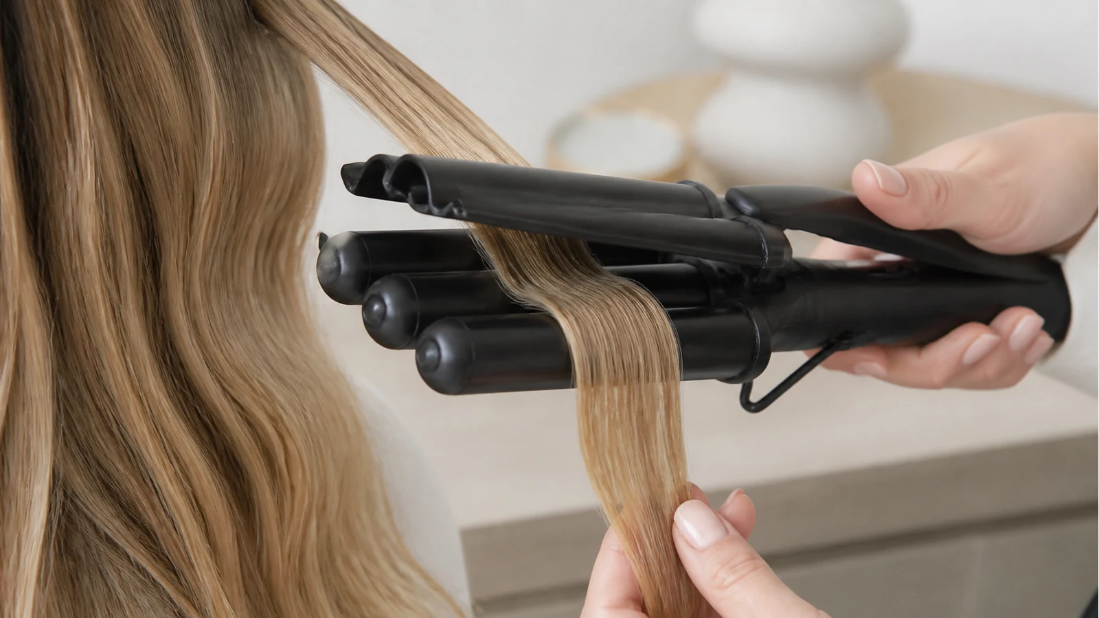 Triple-barrel hair waver releasing a hair section mid-length to avoid scalp clamp marks
